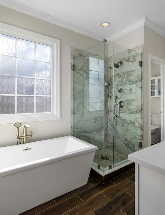 a bathroom with a tub and a shower and a sink