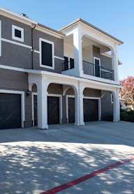 A modern two-story house with a garage and a balcony.