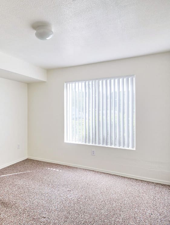 an empty room with white walls and a window