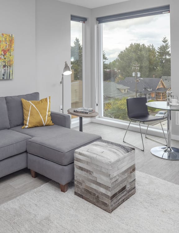 a living room with a gray couch and yellow pillows