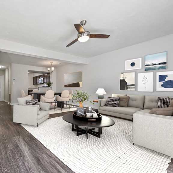 A living room with a grey couch, a pink chair, and a glass coffee table.