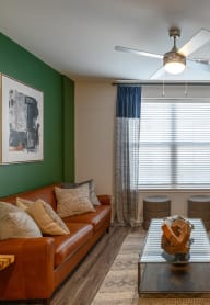 a living room with green walls and a brown leather couch