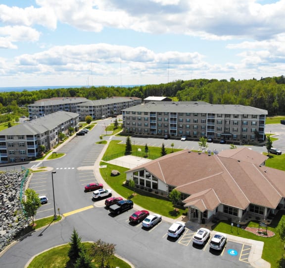 an aerial view of a hotel and parking lot with cars
