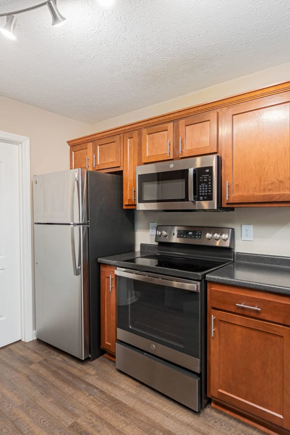 a kitchen with black appliances and wooden cabinets and a refrigerator