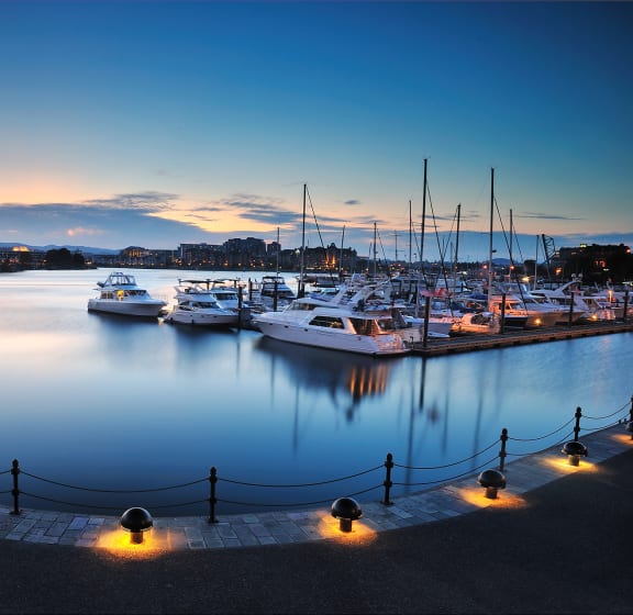 a harbour at dusk with boats in the water and a sunset in the background