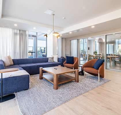 A modern living room with a blue sofa and wooden coffee table.