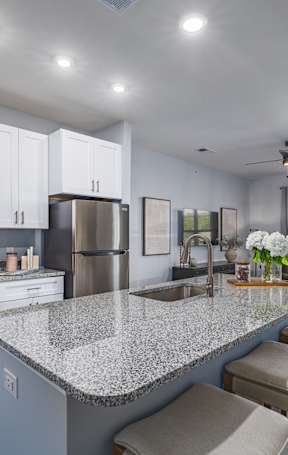 an open kitchen with a granite counter top and stools