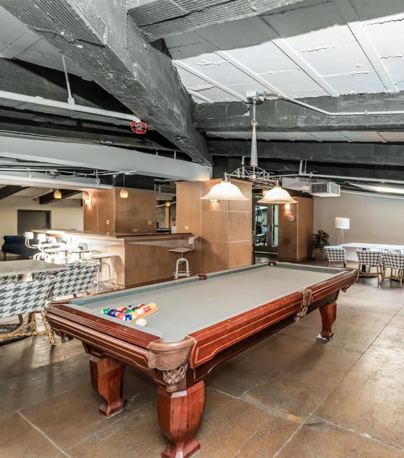 a game room with a pool table and tables