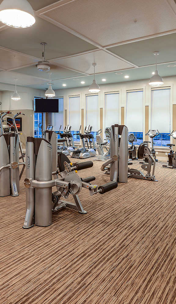a spacious fitness center with cardio machines and weights