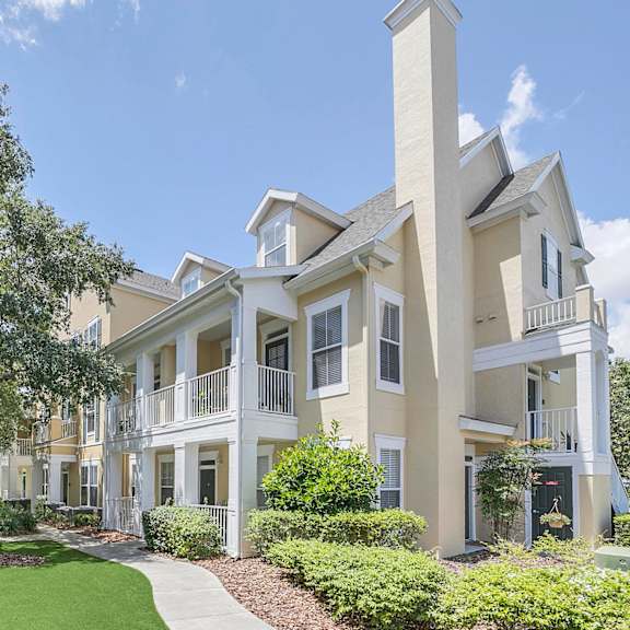 A bedroom with a bed, bench, and window at Northlake Park Apartments, Orlando, FL
