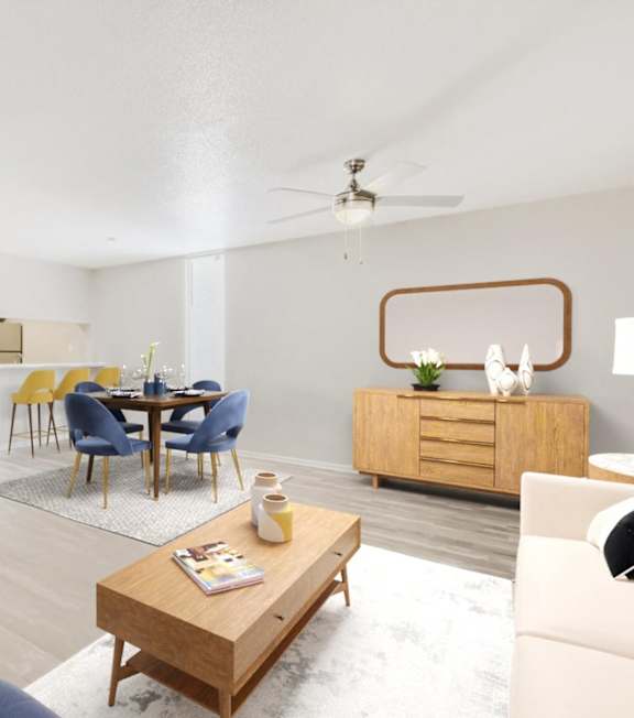 A living room with a blue couch, a wooden coffee table, and a dining table with chairs.