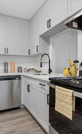A modern kitchen with a stainless steel refrigerator and a black stove top.