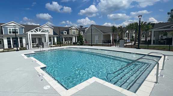 A swimming pool in front of a row of houses.