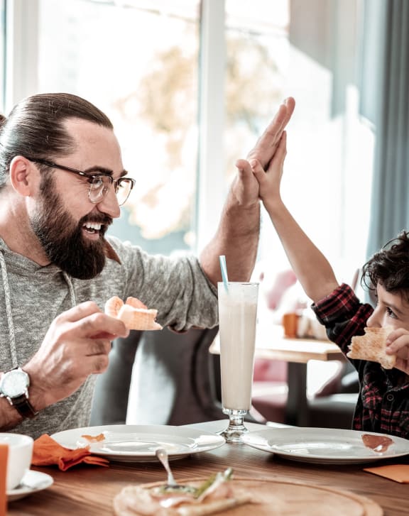 a man and a child sitting at a table eating food at Novella Biltmore, Phoenix Arizona