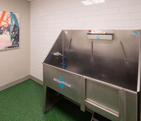 a small room with a refrigerator and a painting on the wall