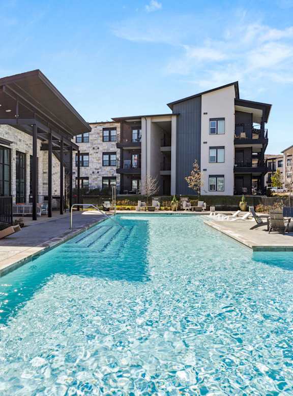 A large swimming pool in front of apartment buildings. at Bridge at Tech Crossing, Austin, Texas