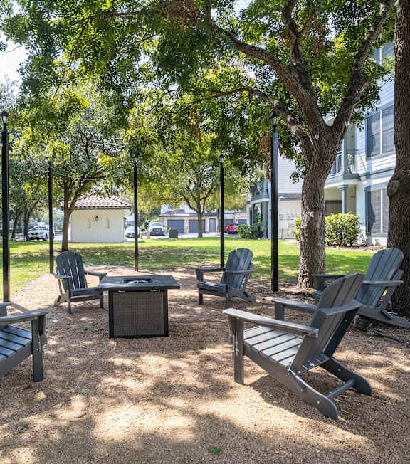 A park with a table and chairs surrounded by trees.