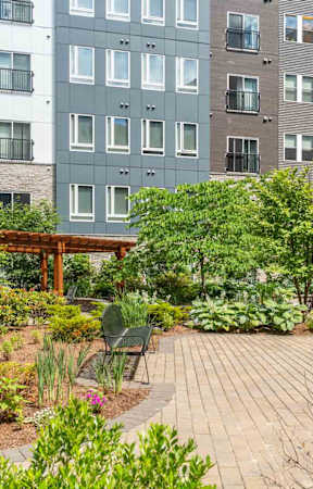A courtyard with a table and chairs surrounded by apartment buildings.