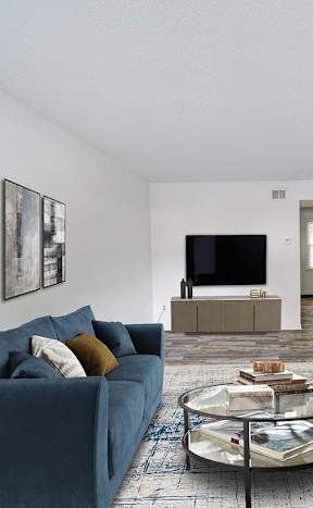 a living room with a blue couch and a television at Timberstone, Charlotte, 28217