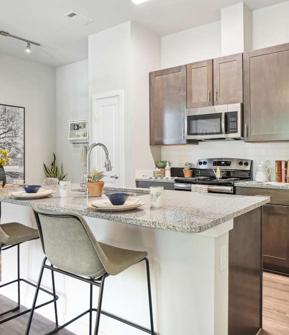 A kitchen with a table and chairs.