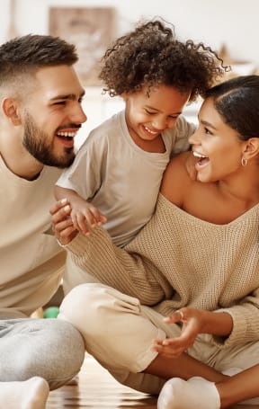 happy family sitting on the floor in the living room at American Spinning Mill, Greenville, SC 29609
