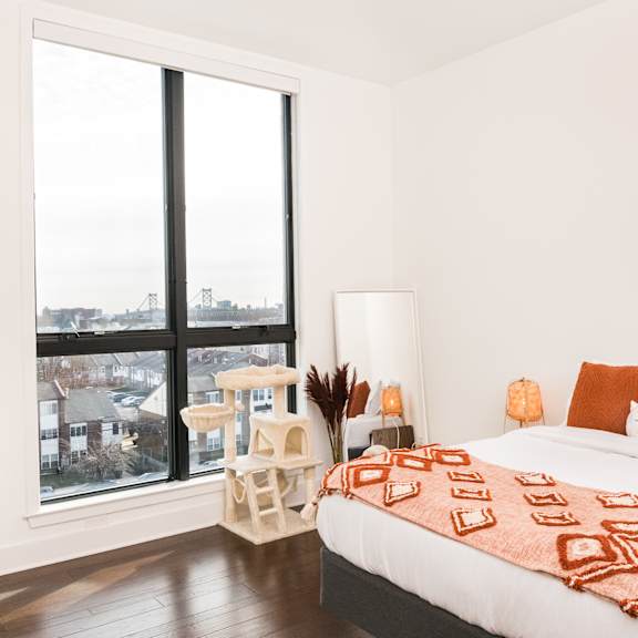 A bedroom with a large bed and a view of the city.