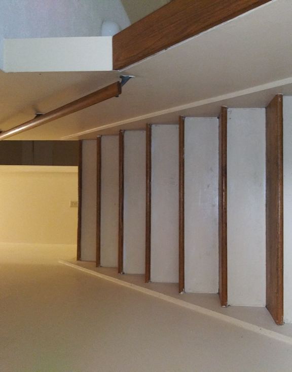 an empty room with white walls and wooden beams