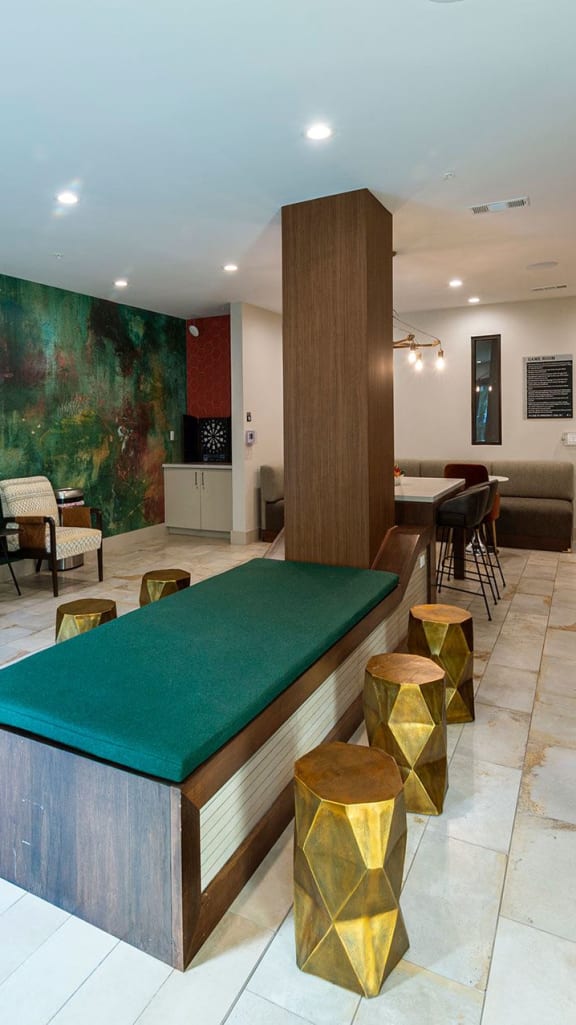 a room with a bar and a large green painting on the wall