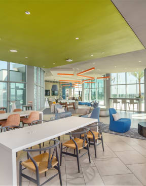 a communal area with tables and chairs in a building with large windows at Vista Brooklynn Apartments, Jacksonville, FL, 32202