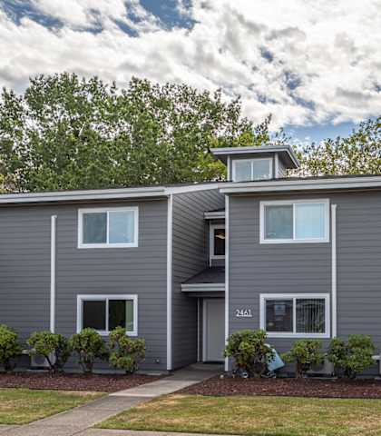 A grey house with a white door and windows.