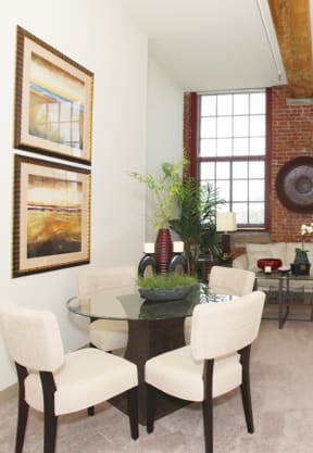 a living room with white walls and a glass table with white chairs