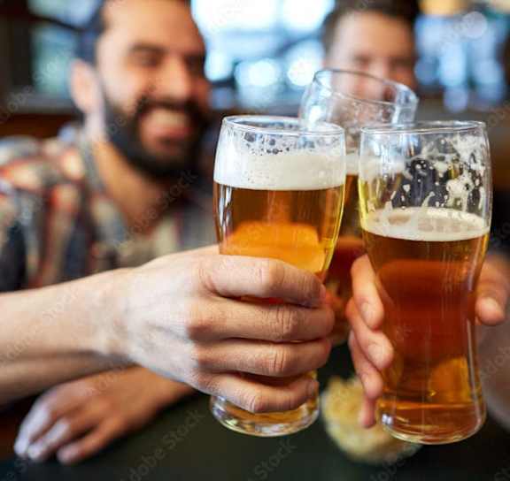 three men holding up glasses of beer at a bar at The Levi Luxury Apartments, McDonough, Georgia