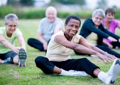 a group of people doing yoga on the grass