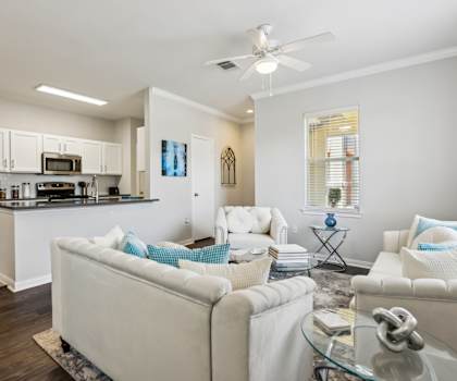 A modern living room with a white couch and a glass coffee table.