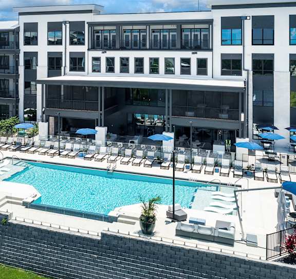 A pool area with sun loungers and a wooden structure at Ironwood Flats in Florida 33511