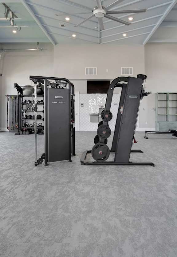 A spacious gym with a variety of equipment including treadmills, weights, and exercise machines.