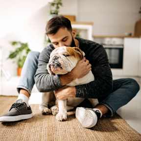 A man is sitting on the floor with his dog.
