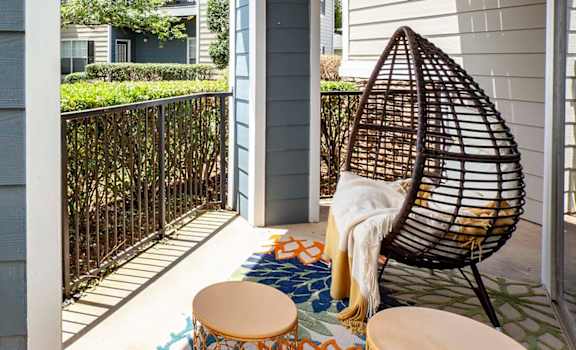 a balcony with two chairs and an egg chair at Thornberry Apartments, Charlotte, 28262