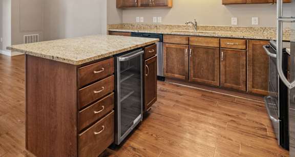 A kitchen with wooden cabinets and a granite countertop.