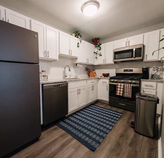 a kitchen with white cabinets and black appliances and a black refrigerator