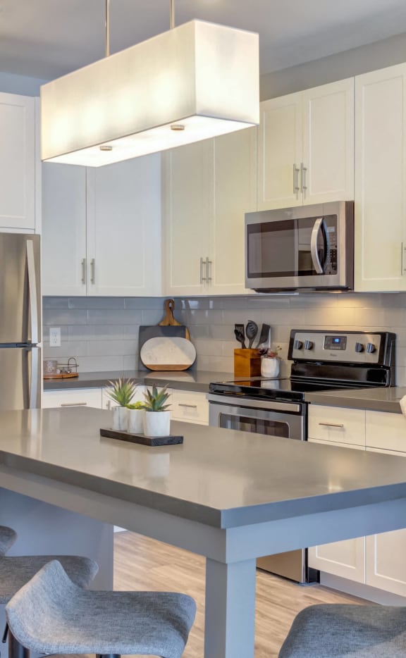 a modern kitchen with stainless steel appliances and white cabinets