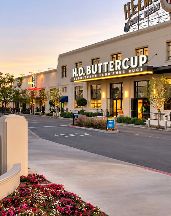 A sign for a bakery and a buttercup shop are displayed in front of a building.