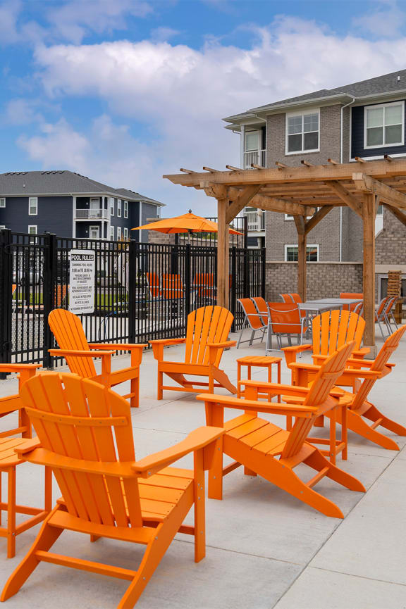 an outdoor patio with blue chairs and a fireplace