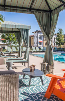 a swimming pool with lounge chairs and umbrellas at Capriana at Chino Hills, Chino Hills, CA, 91709