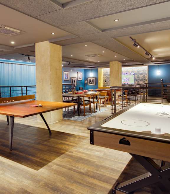 A room with a pool table and a foosball table.