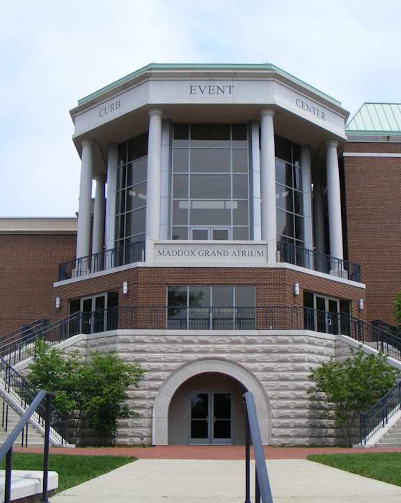 A brick building with a green roof and a sign that says Event Center.