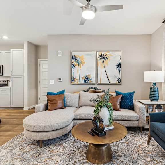 A living room with a grey couch, a blue armchair, and a coffee table.
