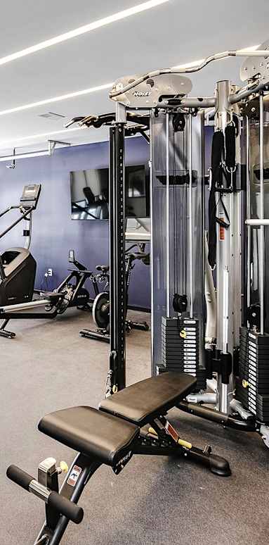 A spacious gym with a variety of equipment including treadmills, weights, and exercise machines.