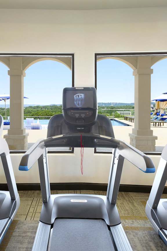 a gym with cardio machines and a view of the beach
