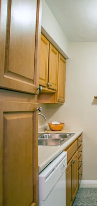 a kitchen with white appliances and wooden cabinets and a refrigerator
